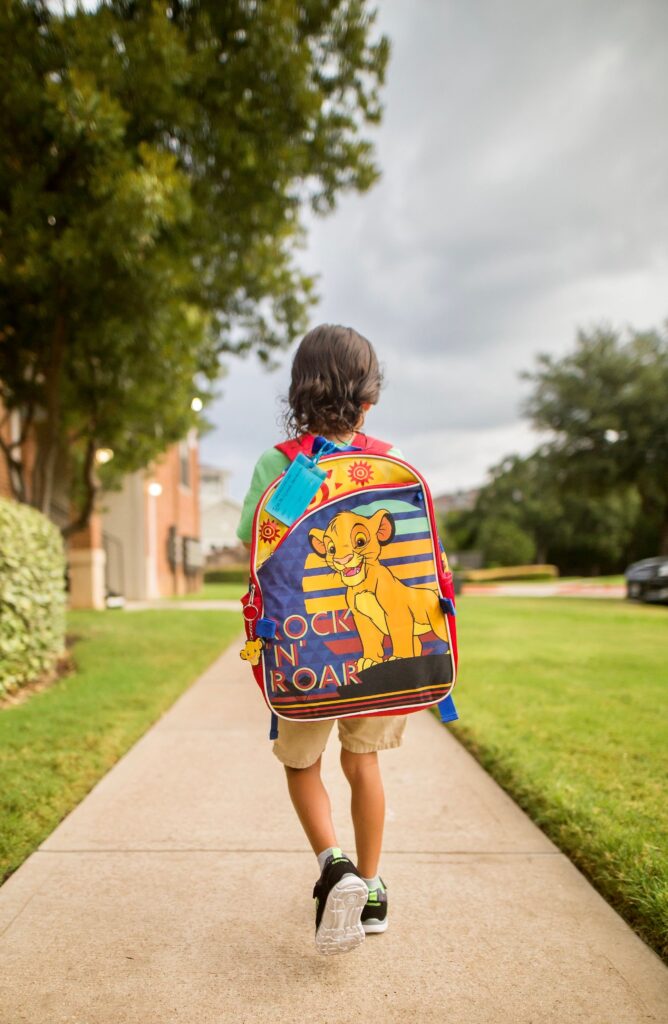 Young child walking to school with a backpack in Maryland during back-to-school season, representing emotional well-being and school readiness.
